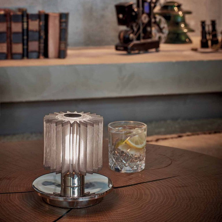 DCW Editions In The Sun Table Lamp on a table with a silver base and silver mesh shade